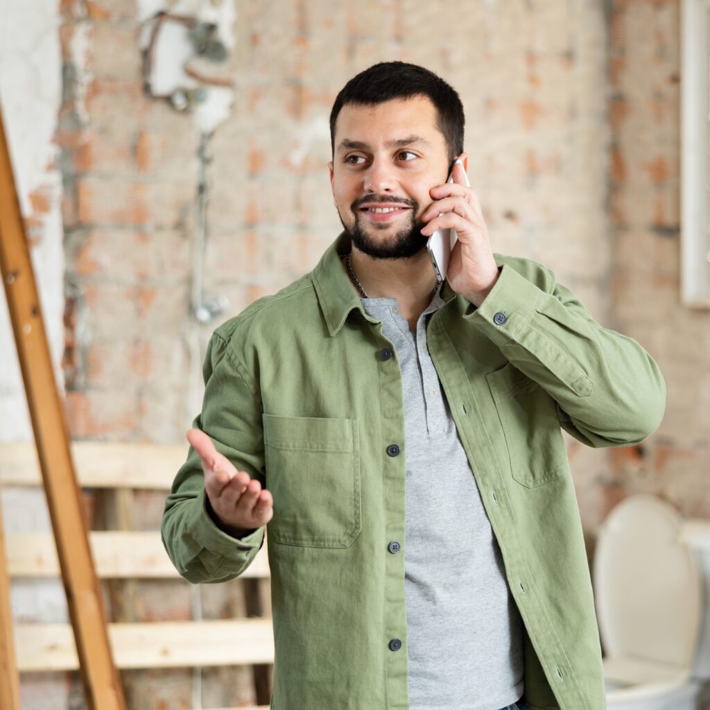 Man smiles while talking on the phone and resolving restoration complaints.
